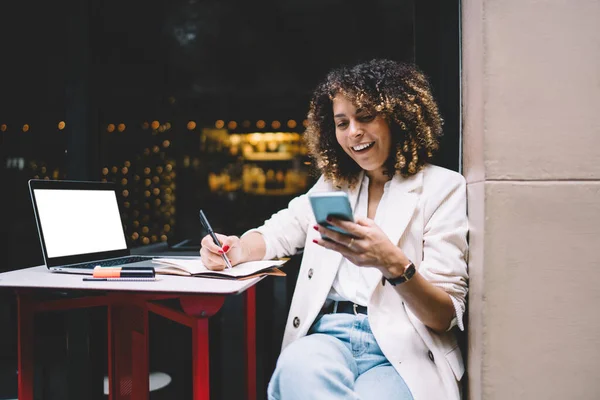 Feliz Freelancer Femenina Ropa Moda Mensajería Teléfono Inteligente Mientras Escribe —  Fotos de Stock