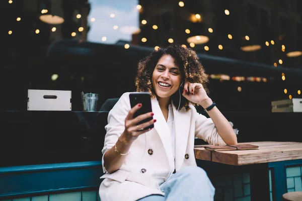 Junge Frau Mit Kopfhörern Lässigem Outfit Und Armbanduhr Surft Smartphone — Stockfoto