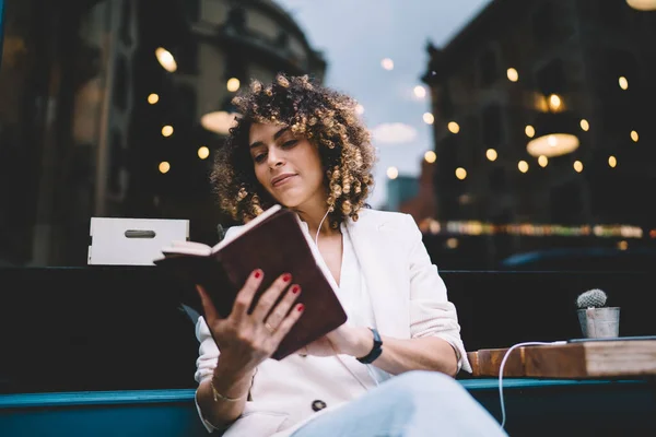 Thoughtful Young Female Curly Brown Hair Stylish Clothes Earphones Reading — Stock Photo, Image