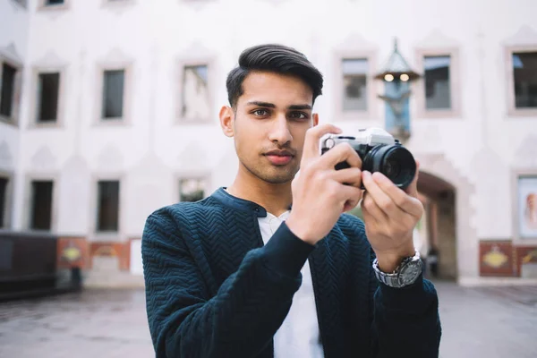 Poważny Młody Etniczny Fotograf Luźnych Ubraniach Robi Zdjęcia Aparatem Fotograficznym — Zdjęcie stockowe