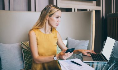 Kafkasyalı ciddi iş kadını, modern iç mekanlarda online alışverişi onaylamak için cep telefonu kullanıyor, müreffeh yönetici serbest piyasadaki alım-satım bildirimini kontrol ediyor.