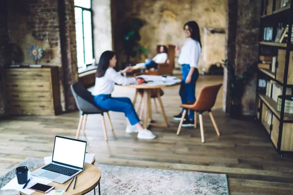 Pequeña Mesa Redonda Con Portátil Con Pantalla Blanco Contra Colegas — Foto de Stock