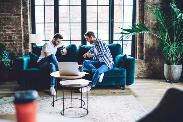 Corpo Inteiro Homens Sentados Sofá Discutindo Ideias Negócios Enquanto Trabalham — Fotografia de Stock