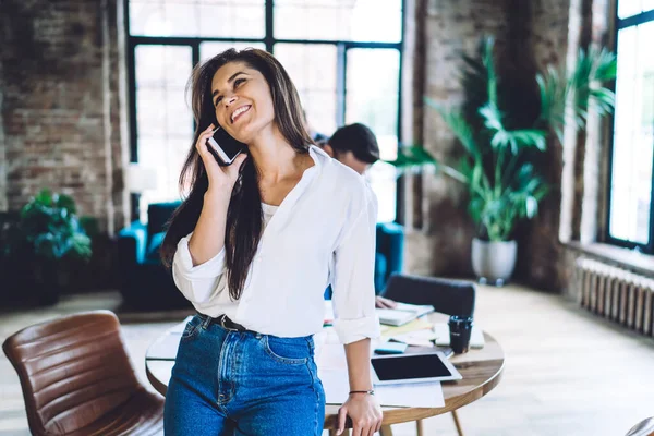 Joven Mujer Sonriente Blusa Blanca Jeans Hablando Smartphone Mientras Está — Foto de Stock