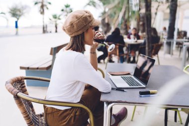 Kafe terasında işten sonra alkollü içki içen genç bir kadının dinlenme ve boş zamanlarının tadını çıkarması, başarılı bir projeyi şarapla kutlayan genç bir kadın serbest yazar, işinden memnun bir şarapla kutluyor.