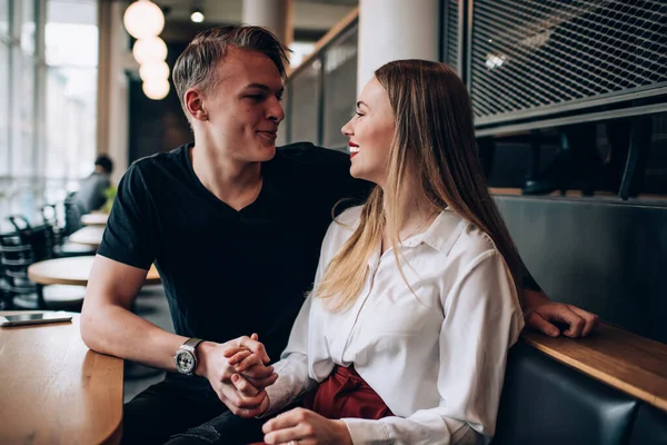Fröhliches Junges Paar Sitzt Händchen Haltend Modernen Café Und Schaut — Stockfoto