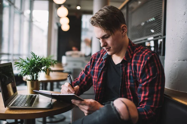 Soustředěný Mladý Trendy Muž Roztrhaných Džínách Kostkované Košili Notebookem Dělat — Stock fotografie