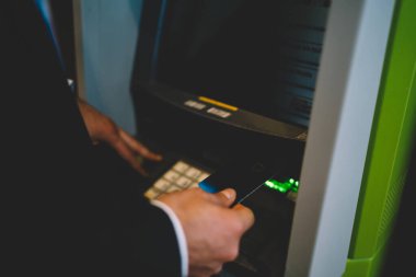 İş adamı, kredi kartı eklenen plastik bankamatik kullanarak ATM 'den para çekmek için çek hesabı bakiyesi, güvenlik doğrulaması için uluslararası para almak için ATM' ye eklenen erkek