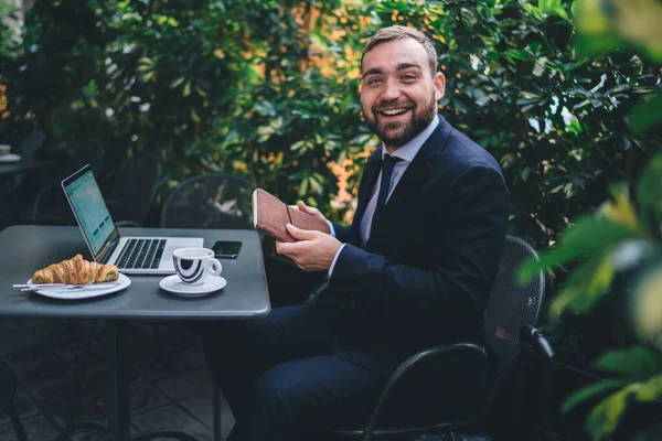 Šťastný Vousatý Chlap Přísném Obleku Sedí Stolu Notebookem Drží Deník — Stock fotografie