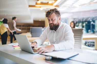 Beyaz sakallı, sistem güncellemesi için program kodlarıyla uzaktan çalışan erkek girişimci, şirket ortaklarıyla mesajlaşan akıllı iş adamı dizüstü bilgisayarda web bankacılığı yapıyor.