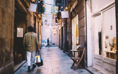 Akşam vakti çantalı, modaya uygun giyinmiş, tarihi merkezde yürüyen, 20 'li yaşlarda, şehrin dar sokaklarında alacakaranlıkta gezen genç bir hippi.