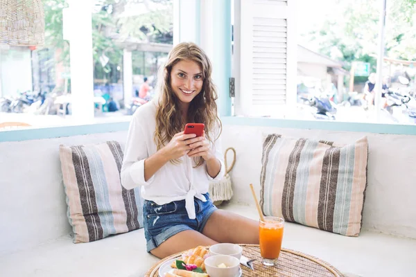 Mujer Despreocupada Teléfono Inteligente Surfing Traje Casual Mientras Sienta Mesa —  Fotos de Stock