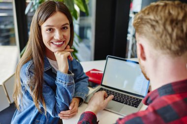 Erkek kullanıcıyla özel ders sırasında kameraya gülümseyen neşeli beyaz öğrencilerin portresi. Yazılım geliştirme ve iş birliği yapan genç bağımsızların uzak mesafe işlerini yaptıkları için bir araya gelmeleri.
