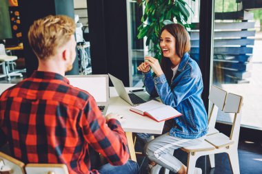 İnternet reklamınız için fotokopi alanı olan masa başında oturan mutlu erkek ve kadın serbest çalışanlar, beyaz öğrenciler üniversite sınavlarını tartışıyor ve öğreniyorlar.