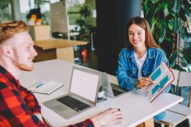 Başarılı erkek ve kadın öğrenciler eğitim ve öğrenim hakkında tartışırken çalışma alanında test ödevi yaparken, işbirliği mesafesinde çalışmayı planlayan Kafkasyalı bağımsız örgütler