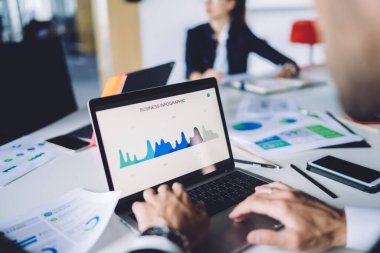 Erkek analistin iş bilgisini incelerken çekilmiş görüntüsü iş sırasında dizüstü bilgisayarla ilgili istatistiksel rapor, web grafik grafiklerini netbook 'taki gösterge paneli uygulaması üzerinden kontrol eden tüccar