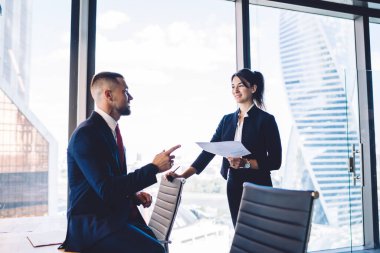 İşbirliği sırasında üretken stratejiyi tartışan kendinden emin erkek ve kadın analistler, Beyaz erkek ve kadın 30 'lu yaşlarda iş yerindeki mali kurumsal raporlar hakkında konuşuyorlar