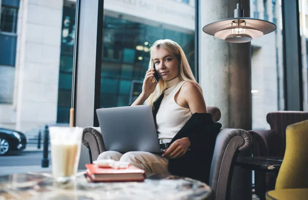 Joven Empresaria Hablando Por Teléfono Mientras Trabaja Netbook Sienta Cafetería — Foto de Stock