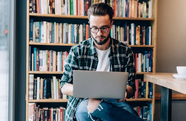 Soustředěný Mladý Freelancer Brýlích Módní Oblečení Pracuje Notebooku Zatímco Sedí — Stock fotografie