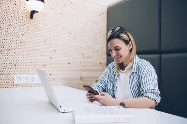 Akıllı telefondaki organizatör uygulaması ile planlama günü düzenleyen güzel bir kadın ekranda uyarı alıyor, üniversitede öğrenim sırasında cep telefonu kullanan beyaz bir kadın cep telefonu kullanıyor.