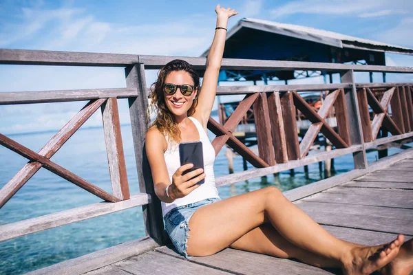 戴着太阳镜的富丽堂皇的女性游客拍摄了一些关于菲律宾度假的积极的现场直播节目 快乐的女孩用现代智能手机制作夏威夷的自拍内容 — 图库照片