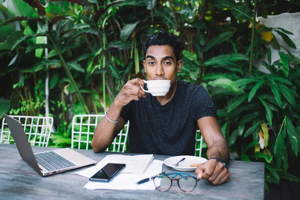 Müder Entspannter Hispanischer Mann Genießt Heißgetränk Während Mit Laptop Und — Stockfoto