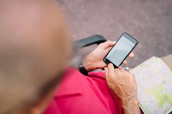 Cropped image of male tourist with location map using smartphone application for tracking gps, selective focus on modern cellular device with mockup screen and copy space area for internet advertising