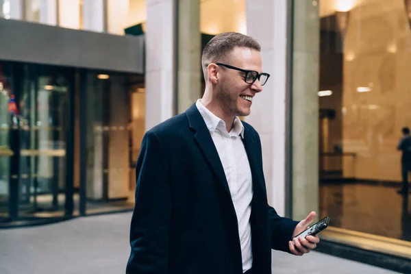 Usmívající Podnikatel Bílé Košili Černé Bundě Brýlemi Pomocí Smartphone Blízkosti — Stock fotografie