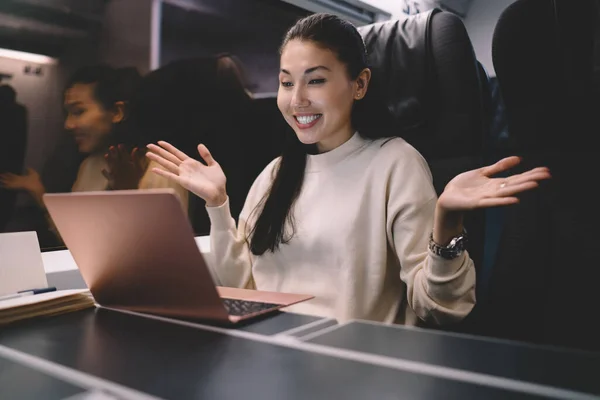 Emotional asian woman gesture and celebrating successful online project checking news while traveling by train with laptop computer, smiling female excited with accomplished job sitting in wagon