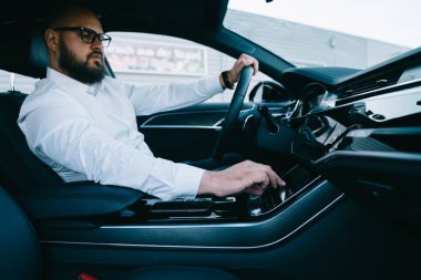 Çağdaş arabada otomotiv direksiyonunda kullanılan çok sistem, resmi giyimli adam sürücü konum kontrolü otomobil teknolojisi üzerinde konum belirleme ekranı GPS üzerinde izleme