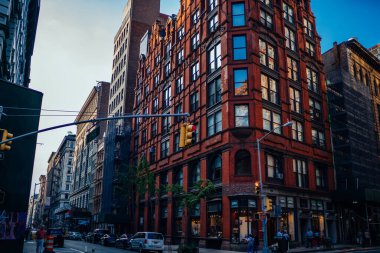Güneşli bir günde otoparkta arabalarla New York 'un yerleşim bölgesinde yüksek eski apartmanlar ve kavşak.