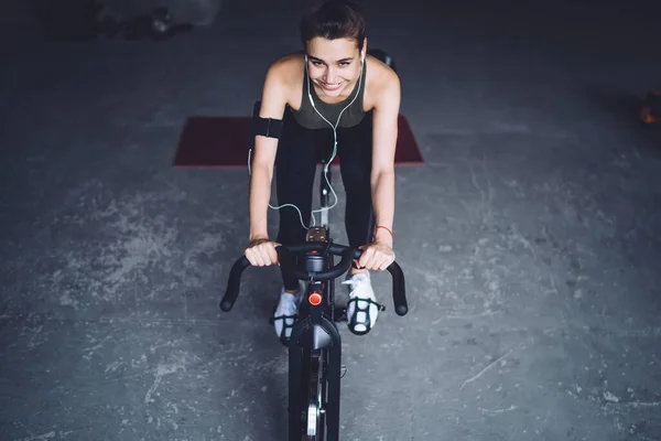 Mulher Branca Sorridente Fones Ouvido Sentado Bicicleta Exercício Playlist Escuta — Fotografia de Stock