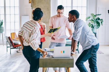 Modern netbook ve kağıt dokümanlarıyla masa başında işbirliği yapan çeşitli yenilikçi öğrenci takımı, zeki profesyonellerin araştırma brifingi bilgileri