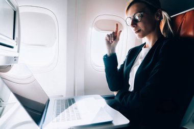 Ekin yoğunlaştırılmış kadın jestleri ve yolcu koltuğunda otururken ve uçuş sırasında netbook okurken başlangıç projesiyle ilgili fikir üretme