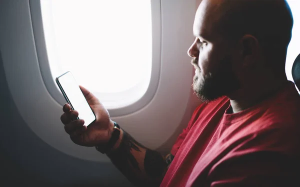 Вид Сбоку Спокойного Парня Смотрящего Дисплей Телефона Помощью Борту Самолета — стоковое фото