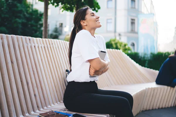 Sidovy Leende Upphetsad Ung Kvinna Vit Skjorta Sitter Ovanliga Träbänk — Stockfoto