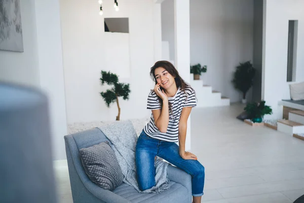 Glada Unga Kvinna Jeans Och Randig Skjorta Sitter Mysig Soffa — Stockfoto