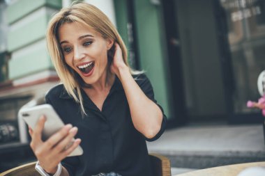 Şok olmuş kadın blogcu, akıllı telefondan 4G 'ye bağlanan kendi web günlüğünün popülaritesi hakkında istatistikler almasına şaşırdı. Akımlar kanalından indirilen videodan etkilenen hipster kız.