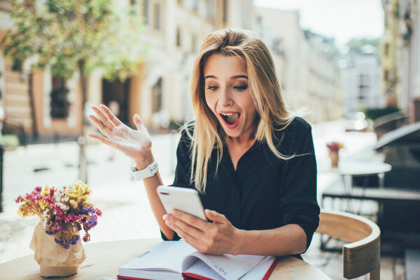 Возбужденная женщина-блоггер с выражением счастья на лице впечатлен полученными в Интернете результатами привлечения последователей удивлен популярностью сайта, удивлен тысячелетие чудо с телефоном
