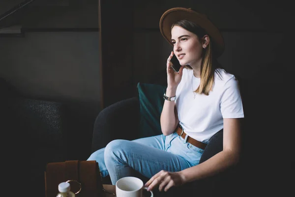 Modern Kafeteryadaki Koltukta Oturmuş Bir Fincan Sıcak Içecekle Akıllı Telefondan — Stok fotoğraf