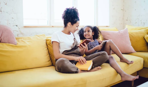 Sorrindo Jovem Mulher Negra Segurando Smartphone Livro Falando Com Pequena — Fotografia de Stock