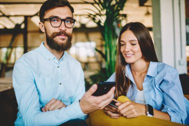 Optik gözlüklü beyaz adamın portresi göz koruması için kameraya bakıyor kaygısız kadın, genç adam ve kadın cep telefonu aygıtıyla blog yazıyor.