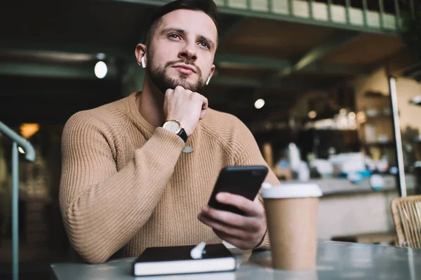 Bărbat Grijuliu Pulover Bej Ascultând Muzică Timp Stătea Masă Smartphone — Fotografie, imagine de stoc