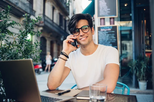 Jovem Feliz Freelancer Cabelos Elegantes Óculos Pulseiras Pulso Sorrindo Enquanto — Fotografia de Stock