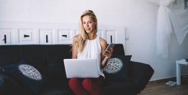 Akıllı telefon aygıtını tutan serbest çalışanın portresi ve günlerce uzaktaki online çalışma için kameraya bakmak, yazılım geliştirme sürecinde dosyaları paylaşmak için bluetooth bağlantısı kullanmak