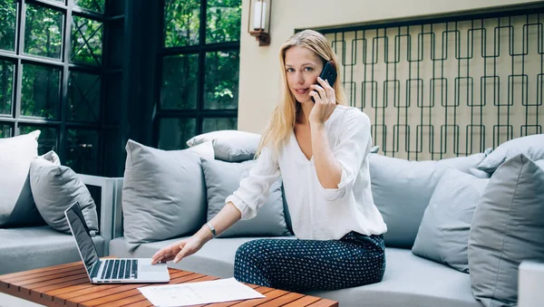 Fröhliche Managerin Die Handy Spricht Und Touchpad Laptop Benutzt Während — Stockfoto