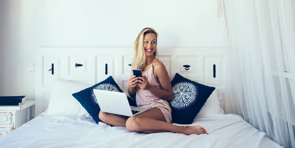 Jovem Loira Satisfeita Pijama Seda Rindo Olhando Para Longe Cama — Fotografia de Stock