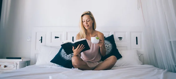 Inteligente Mulher Loira Loira Alegre Pijama Sorrindo Enquanto Livro Com — Fotografia de Stock