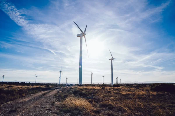 低角度風車は 緑のエネルギーを発生させ 青空に対して乾燥した草と空の農場フィールドに位置しています — ストック写真