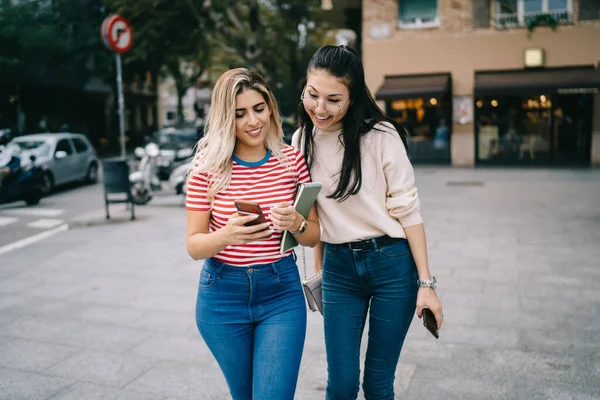 千禧年的嬉皮士女孩一边阅读网络新闻 一边通过现代手机追踪自己的位置 迷人的女性游客在城市观光时使用智能手机进行无线浏览和联网 — 图库照片